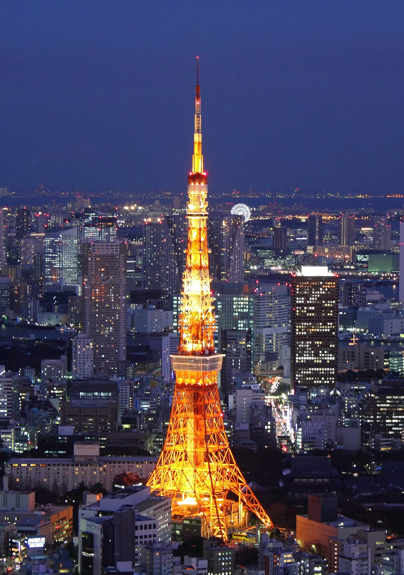 Tokyo Tower lit orange and white at night above the city.